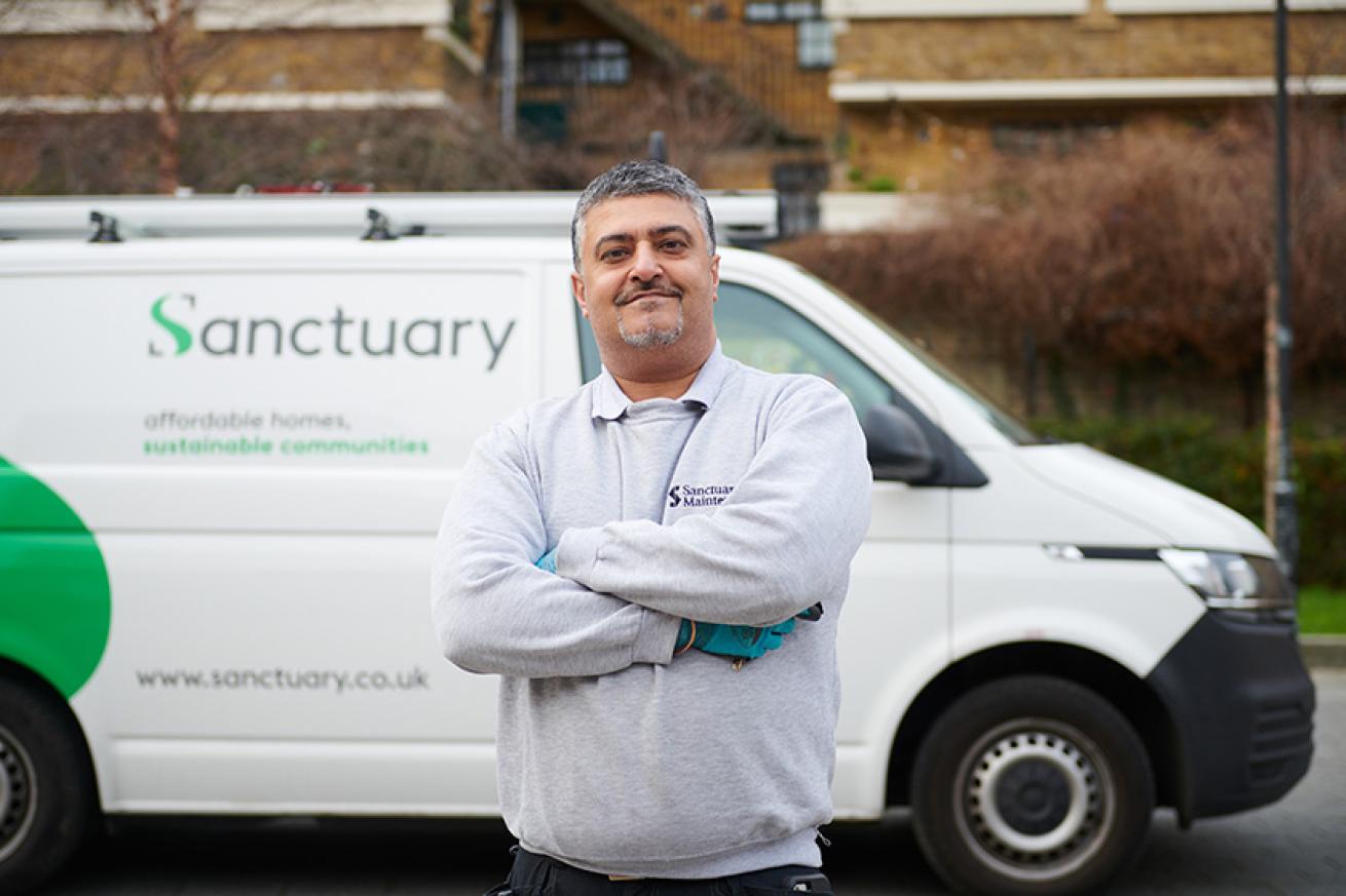 Sanctuary Maintenance employee standing proudly next to a Sanctuary branded van